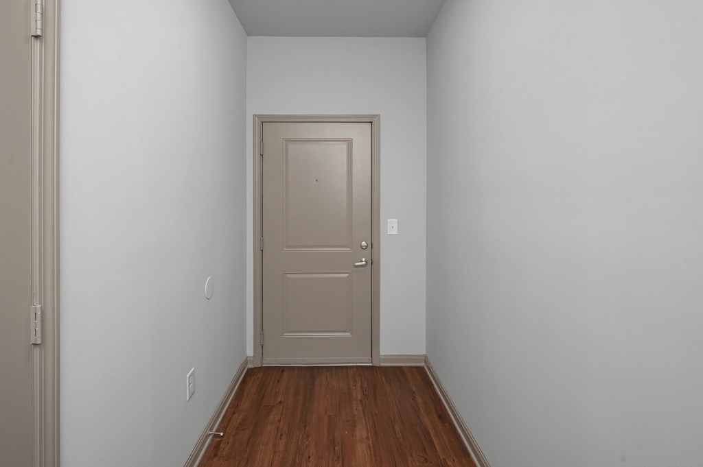 A room with a wooden floor and a white door.